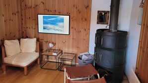 A cozy living room with a sofa, a small table, a lamp, a framed picture, and a wood-paneled wall. - Roccabella Appartement/Fewo, Dusche oder Bad, WC, 2 Schlafräume by Interhome (Bivio)