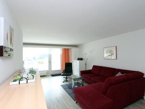A modern living room with a wooden table, red sofa, and a black chair. - Tgesa La Niva 11 Appartement/Fewo, Bad, WC, 2 Schlafräume by Interhome (Savognin)