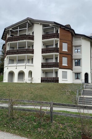 A multi-story residential building with balconies, a flat roof, and a front entrance with steps. - Casa Surselva Whg Bilger Appartement/Fewo, Bad, WC, 2 Schlafräume by Interhome (Savognin)
