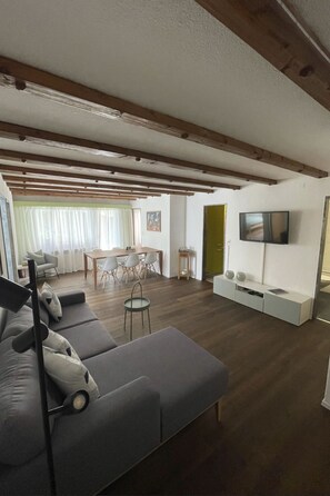 A modern living room with a sofa, a dining table, and a TV. - Appartamento Wyss Appartement/Fewo, Bad, WC, 3 Schlafräume by Interhome (Bivio)