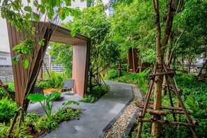 A garden pathway with a wooden pergola, seating area, and climbing plants. - Noodle Nest..  Central Rama 9 - Comfortable Stay near MRT (Krung Thep Maha Nakhon)