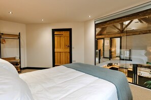 Ein Schlafzimmer mit einem Bett, einer Holztür, einem Kleiderschrank und einer Glastür, die auf einen Balkon führt.