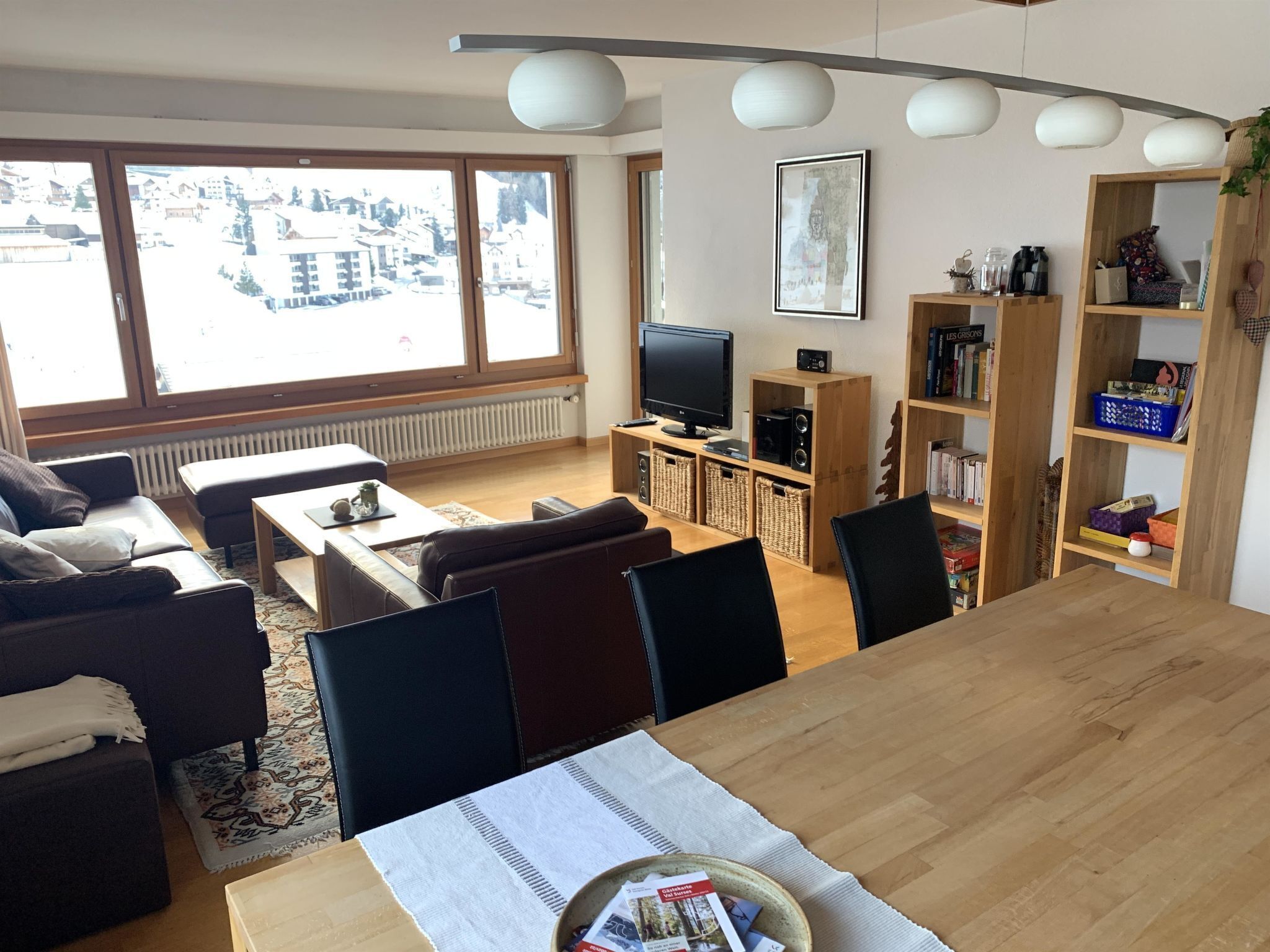 Un salon avec un canapé, une table basse, un téléviseur et une bibliothèque.