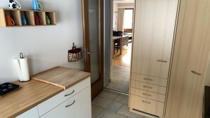Et køkken med træbordplade, hvide skabe og et viskestykke hængende.