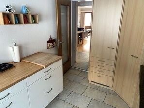 A kitchen with a wooden countertop, white cabinets, and a hanging kitchen towel. - Tgesa Marlotscha Appartement/Fewo, Dusche oder Bad, WC, 3 Schlafräume by Interhome (Savognin)