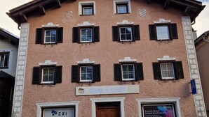 A building with a symmetrical facade, multiple windows with shutters, and a central entrance. - Haus Rizzi Appartement/Fewo, Dusche, WC, 1 Schlafraum by Interhome (Bivio)