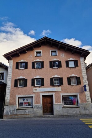 A building with a symmetrical facade, multiple windows with shutters, and a central entrance. - Haus Rizzi Appartement/Fewo, Dusche, WC, 1 Schlafraum by Interhome (Bivio)