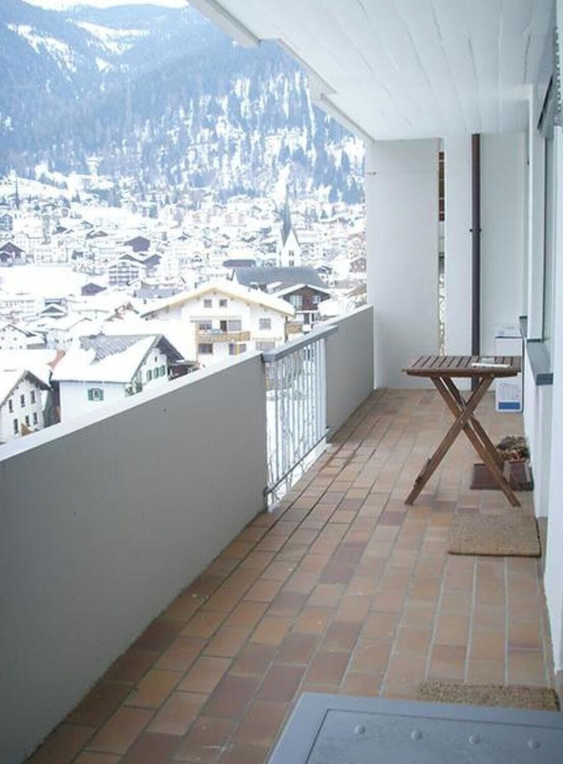 A balcony with a view of a town and mountains.