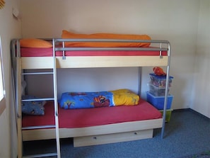 A bunk bed with two levels, a small drawer under the lower bunk, and a blue storage box on the right. - Sot Spondas 15 Appartement/Fewo, Bad, WC, 2 Schlafräume by Interhome (Savognin)