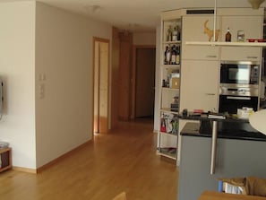A kitchen with a microwave, oven, and various kitchen items on shelves. - Sot Spondas 15 Appartement/Fewo, Bad, WC, 2 Schlafräume by Interhome (Savognin)