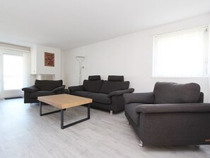 Ein modernes Wohnzimmer mit zwei Sofas, einem Couchtisch und einer Stehlampe.