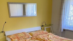A bed with a patterned bedspread, a bedside table, and a nightstand. - Gelgia Sommer-Salis Appartement/Fewo, Bad, WC, 2 Schlafräume by Interhome (Bivio)