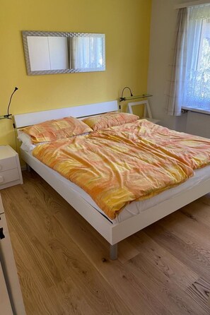 A bed with a patterned bedspread, a bedside table, and a nightstand. - Gelgia Sommer-Salis Appartement/Fewo, Bad, WC, 2 Schlafräume by Interhome (Bivio)