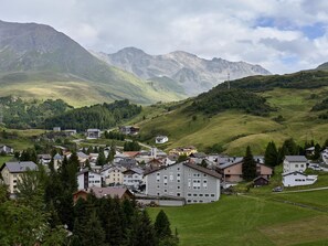 A mountainous town with a prominent hotel building, surrounded by lush greenery and distant peaks. - Bergnest 4 Appartement/Fewo, Bad, WC, 2 Schlafräume by Interhome (Bivio)