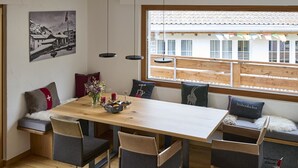 A dining area with a wooden table, chairs, and a bench with cushions. - Bergnest 4 Appartement/Fewo, Bad, WC, 2 Schlafräume by Interhome (Bivio)