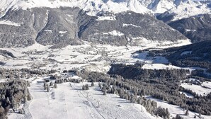 A snow-covered mountain landscape with a small town nestled in the valley.