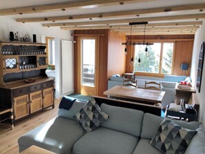 A cozy living area with a sofa, a dining table, and a kitchen with wooden cabinets. - Ferienwohnung Kleiner Moor Appartement/Fewo, Bad, WC, 1 Schlafraum by Interhome (Bivio)