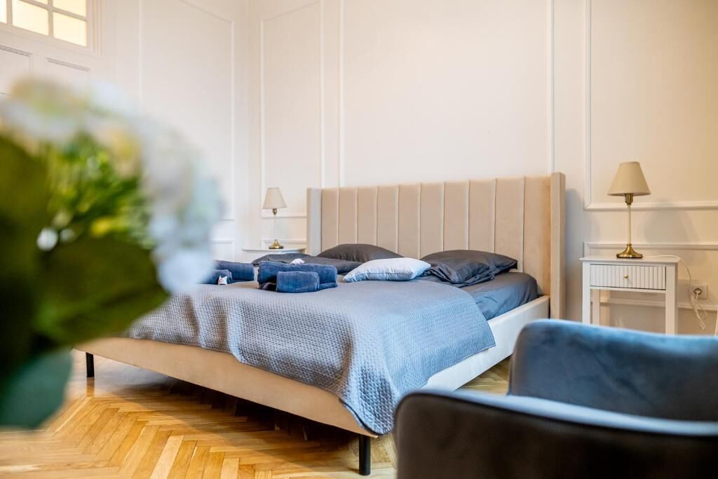 A bedroom with a bed, bedside tables, a lamp, and a chair.