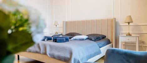 A bedroom with a bed, bedside tables, a lamp, and a chair.