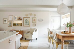 A dining area with a wooden table, chairs, and a hanging light fixture. - Thatched idyll from the 1800s in Voldtofte (Glamsbjerg)