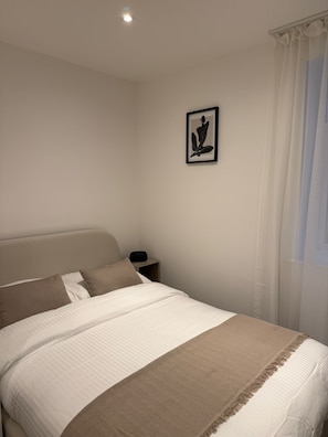 A neatly made bed with a headboard, a bedside table with a lamp, and a framed picture on the wall. - Sunniside Sunderland Apartment, walking distance to city centre (Sunderland)