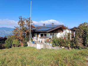 Une maison moderne dotée d’un toit en pente, de panneaux solaires et de fondations en pierre.