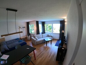 Un salon moderne avec un canapé, une table à manger et un téléviseur.