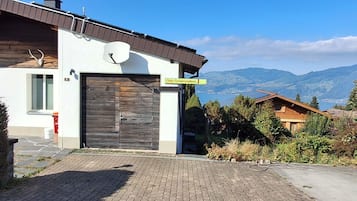 Un edificio moderno con una puerta de garaje grande, una antena parabólica y un letrero que dice 'Chilis Ferienresidenz'.