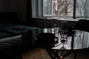 Een eettafel met een zwarte kom, twee glazen en een lepel.