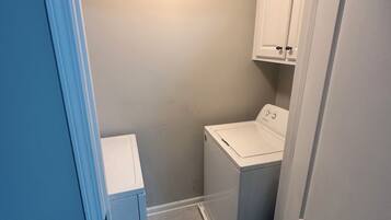 A laundry room with a washing machine and cabinets.