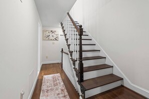 A staircase with wooden steps and white railings, leading to an upper floor. - Stylish 3-bedroom, 3-bath townhome in one of Baltimore's most walkable neighborhoods steps from Little Italy, Fells Point's cobblestone streets, and the Inner Harbor waterfront (Baltimore)