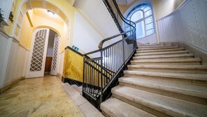 A grand staircase with a black railing, leading to an upper floor. - The Gem of Downtown: Scenic Boutique Hideaway by the Promenade – 312 (Budapest)