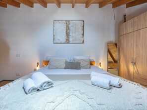 A bedroom with a bed, pillows, a blanket, and towels. - Casa Abraço - River View Terrace in Ferragudo (Ferragudo)