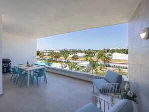 A balcony with a pool view, outdoor seating, and a grill. - Lagos Odyssey - Sea Views and Dona Ana Bay (Lagos)
