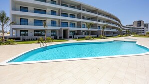 A modern hotel with a swimming pool, multiple balconies, and a clear sky. - Lagos Odyssey - Sea Views and Dona Ana Bay (Lagos)