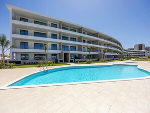A modern hotel with a swimming pool, multiple balconies, and a clear sky. - Lagos Odyssey - Sea Views and Dona Ana Bay (Lagos)