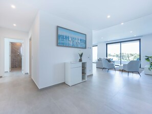 A modern living room with a large window, a white sofa, and a coffee table. - Lagos Odyssey - Sea Views and Dona Ana Bay (Lagos)