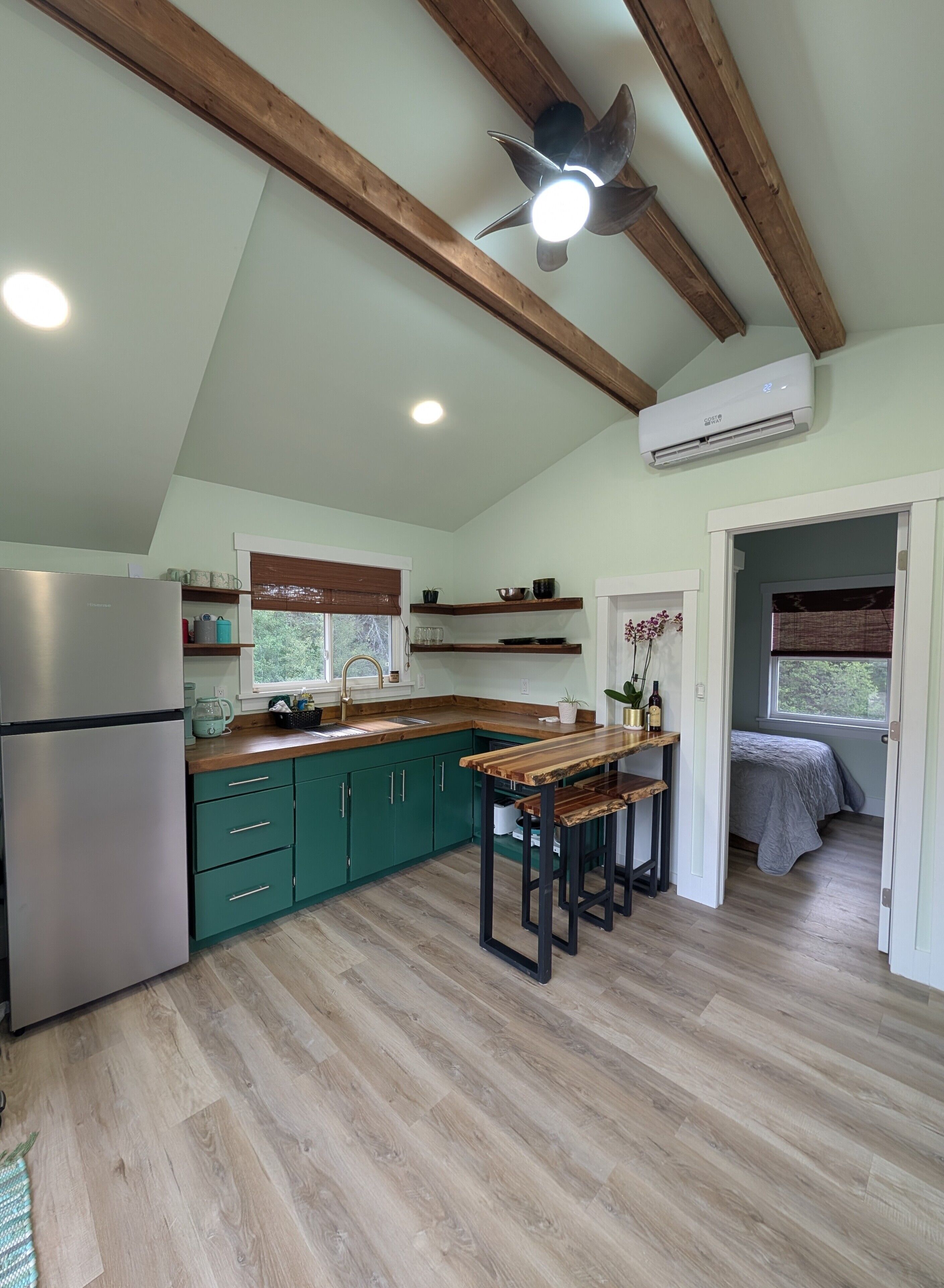 Une cuisine avec un plafond en bois, un banc intégré et un réfrigérateur.