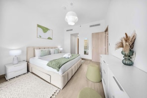 Una camera da letto moderna con un letto, un comodino, una lampada e uno specchio.