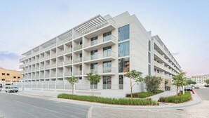 A modern multi-story building with balconies and large windows. - StayShort - Stylish 1 Bedroom in JVC - Sleeps 4 (JVC)