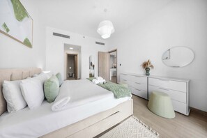 Een moderne slaapkamer met een bed, nachtkastjes, een dressoir en een spiegel.