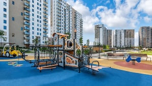A playground with climbing structures and a basketball court, surrounded by high-rise residential buildings. - Letnica 159 | Sea View | 2 Bedrooms (Gdańsk)