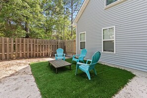 A backyard with a wooden deck, a lawn, and a house with a window. - My Three Buoys𓇼Sleeps 10+Game Room+Spacious (Oak Island)