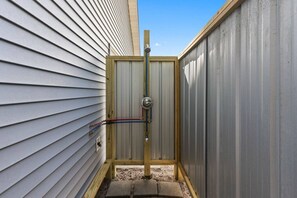 A small, enclosed outdoor area with a metal door, a wooden frame, and visible electrical wiring. - My Three Buoys𓇼Sleeps 10+Game Room+Spacious (Oak Island)