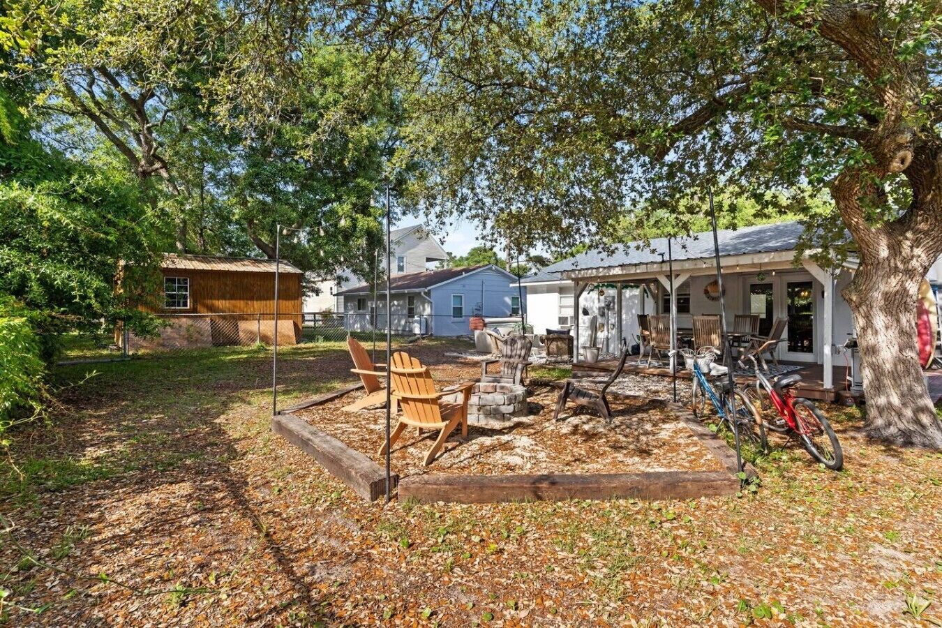 A backyard with a wooden deck, outdoor seating, and a bicycle.