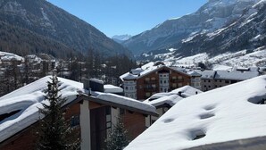 Un villaggio montano innevato con edifici e cielo sereno.