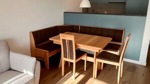 Una cucina moderna con mobili a incasso e un'area pranzo con tavolo e sedie in legno.