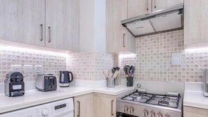 Eine moderne Küche mit Gasherd, Backofen, Kaffeemaschine und Toaster.