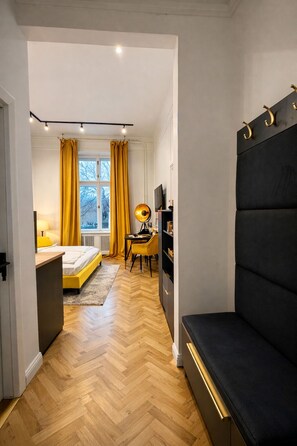 A modern bedroom with a bed, a desk, and a large black sofa. - Between the River & Pedestrian Zone: Exclusive Central Nook – 311 (Budapest)