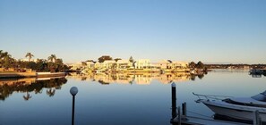 A waterfront property with a marina, calm water, and a row of buildings. - Mandurah Holiday Apartments   ‘Pelican’ (Dudley Park)